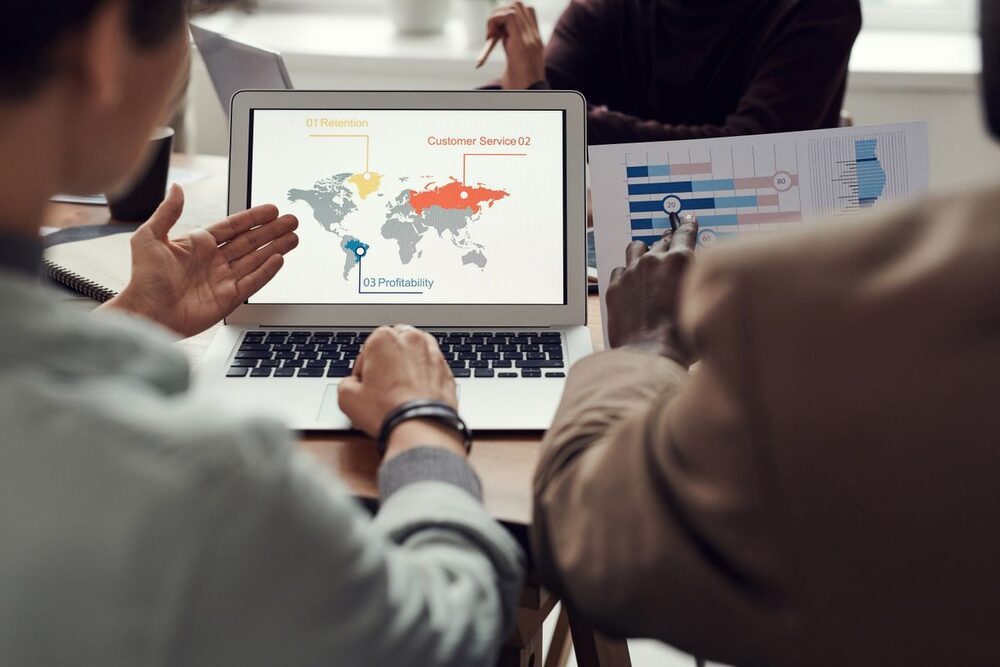 Equipo analizando datos geográficos y financieros en pantalla